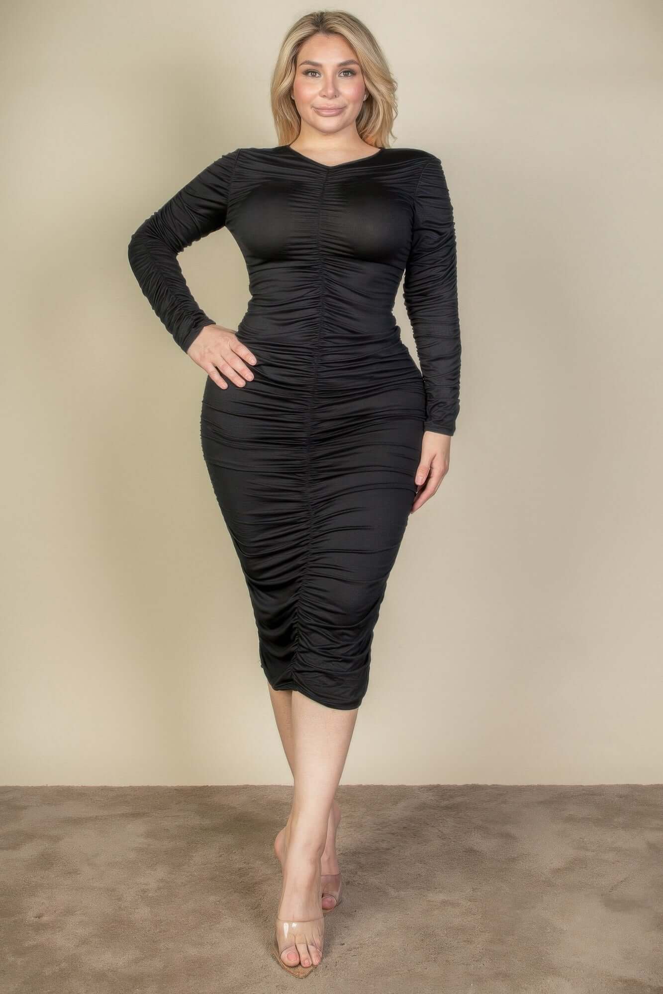Woman wearing a Plus Size Ruched Long Sleeve Midi Dress in black, highlighting chic design and comfortable fit.