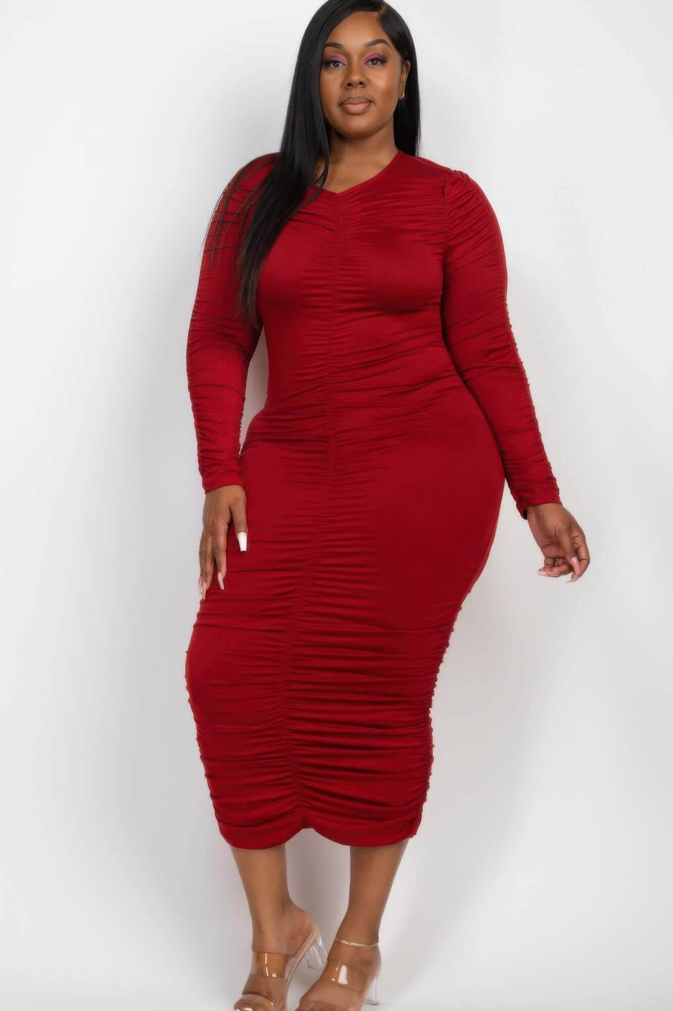 Woman wearing Plus Size Ruched Long Sleeve Midi Dress in red, showcasing curve-enhancing, chic design and comfort with stretch jersey fabric.