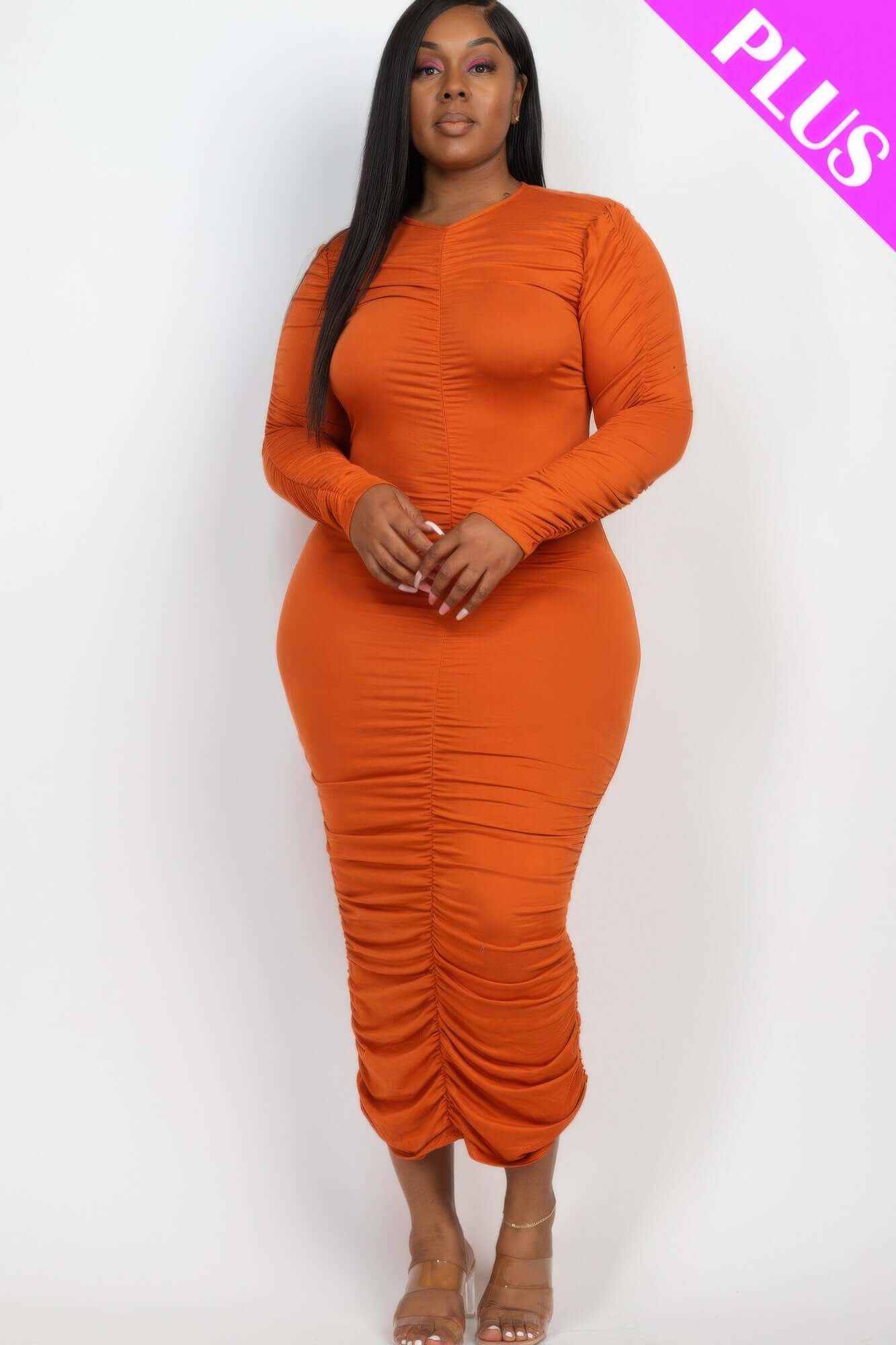 Woman wearing Plus Size Ruched Long Sleeve Midi Dress in orange, showcasing a chic and comfortable design.